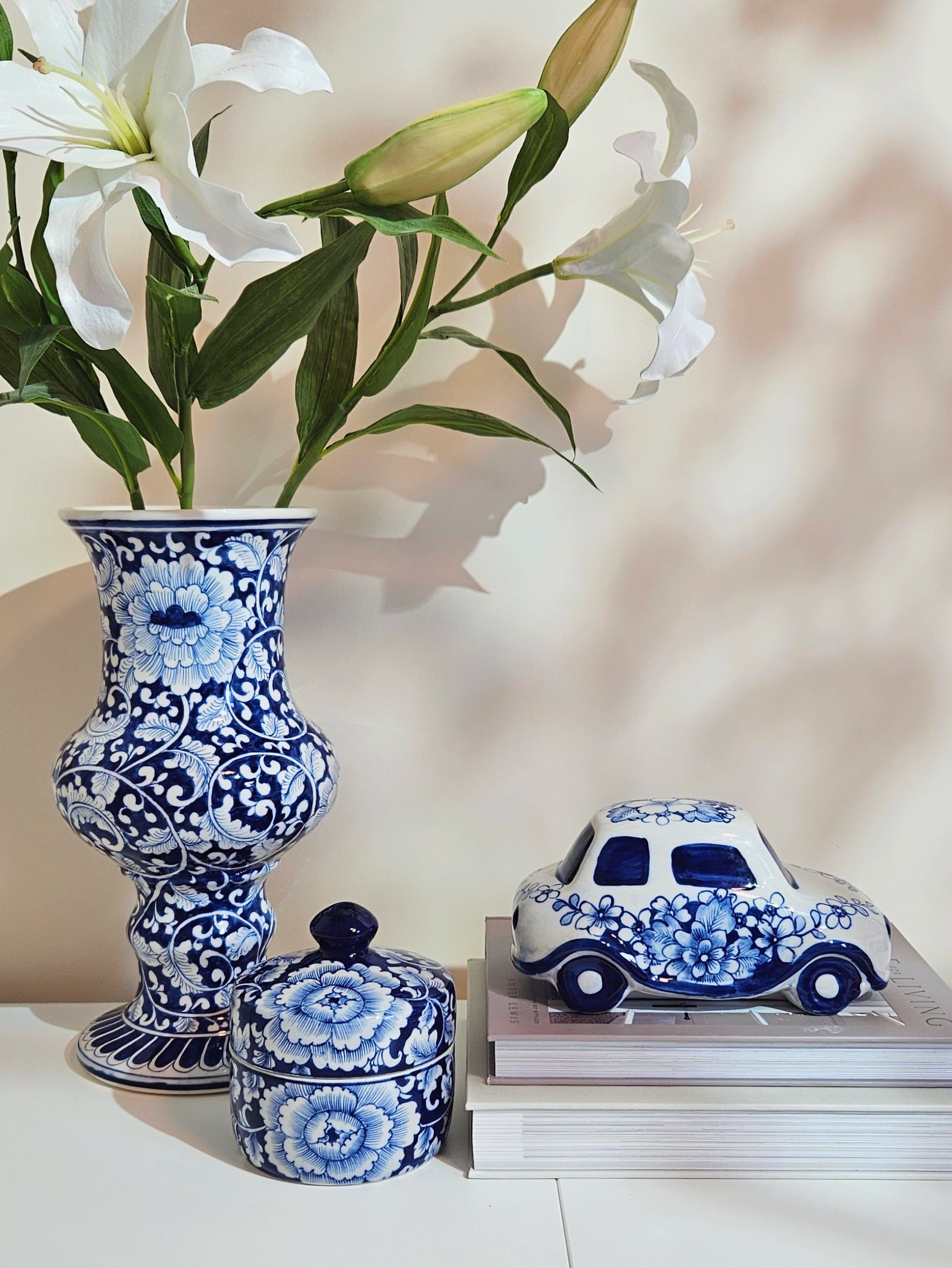 Chinoiserie Blue and white Porcelain car figurine being display next to a decorative jar and flower vase.