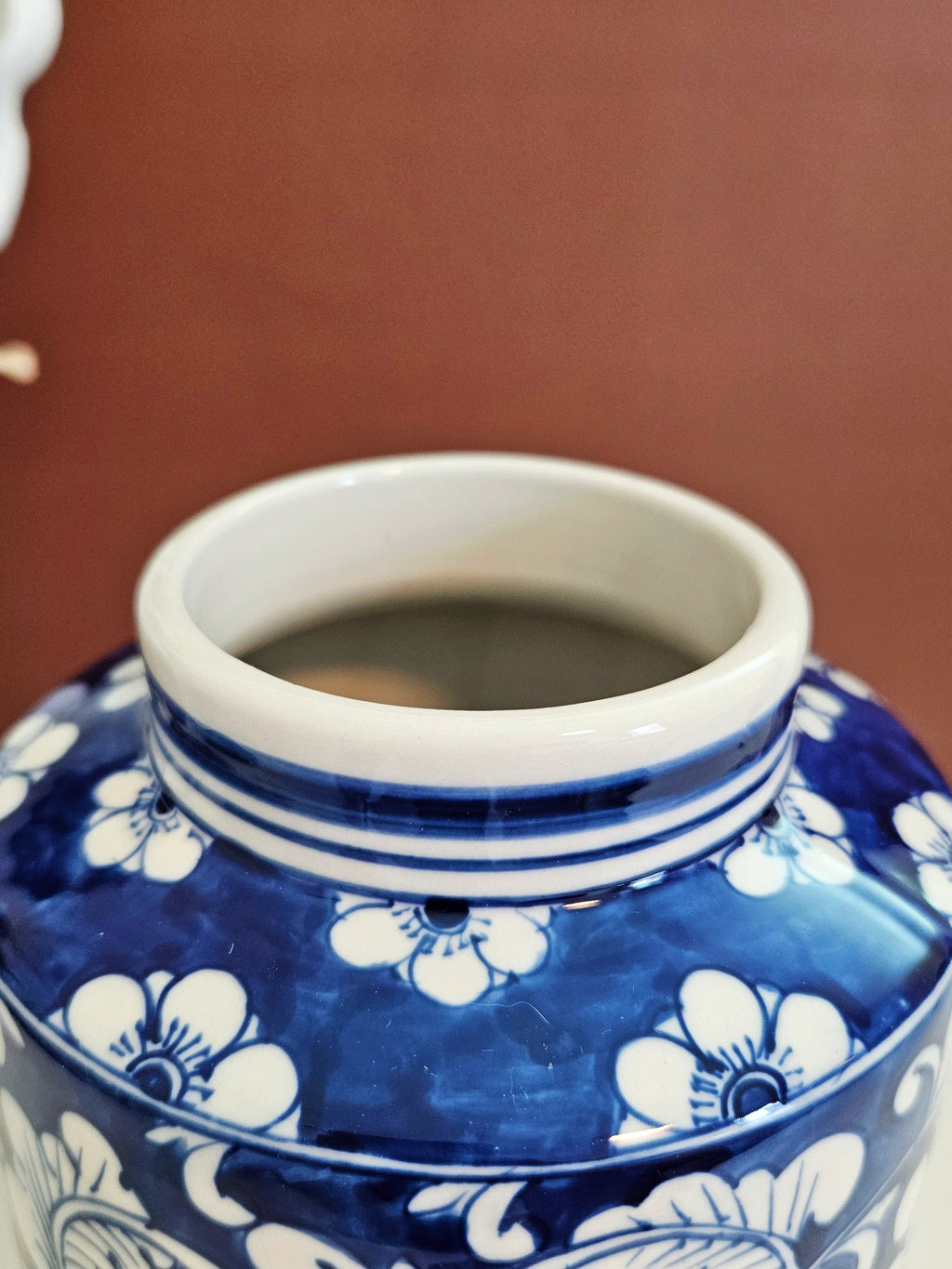 close up view of the top opening of the blue and white chinoiserie tall jar with floral pattern