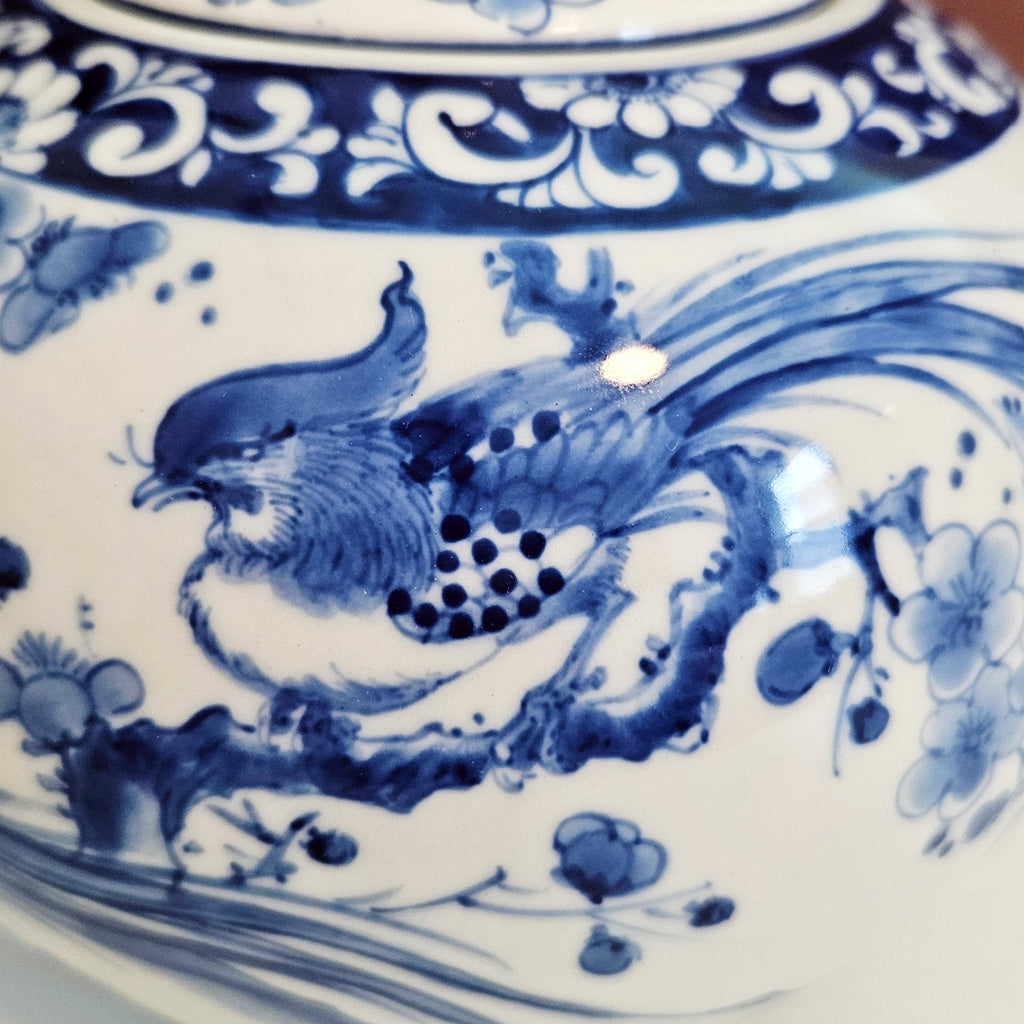 Close-up of a blue and white porcelain ceramic piece featuring a detailed pheasant bird  with floral motifs.