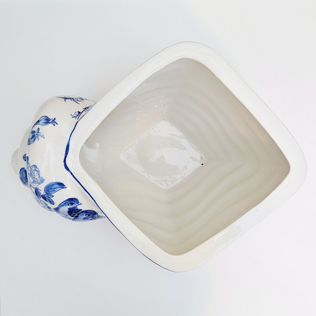 An antique-style ceramic planter pot with a shell shape glazed interior and a side handle decorated in blue floral patterns, shown from an overhead angle on a white background.