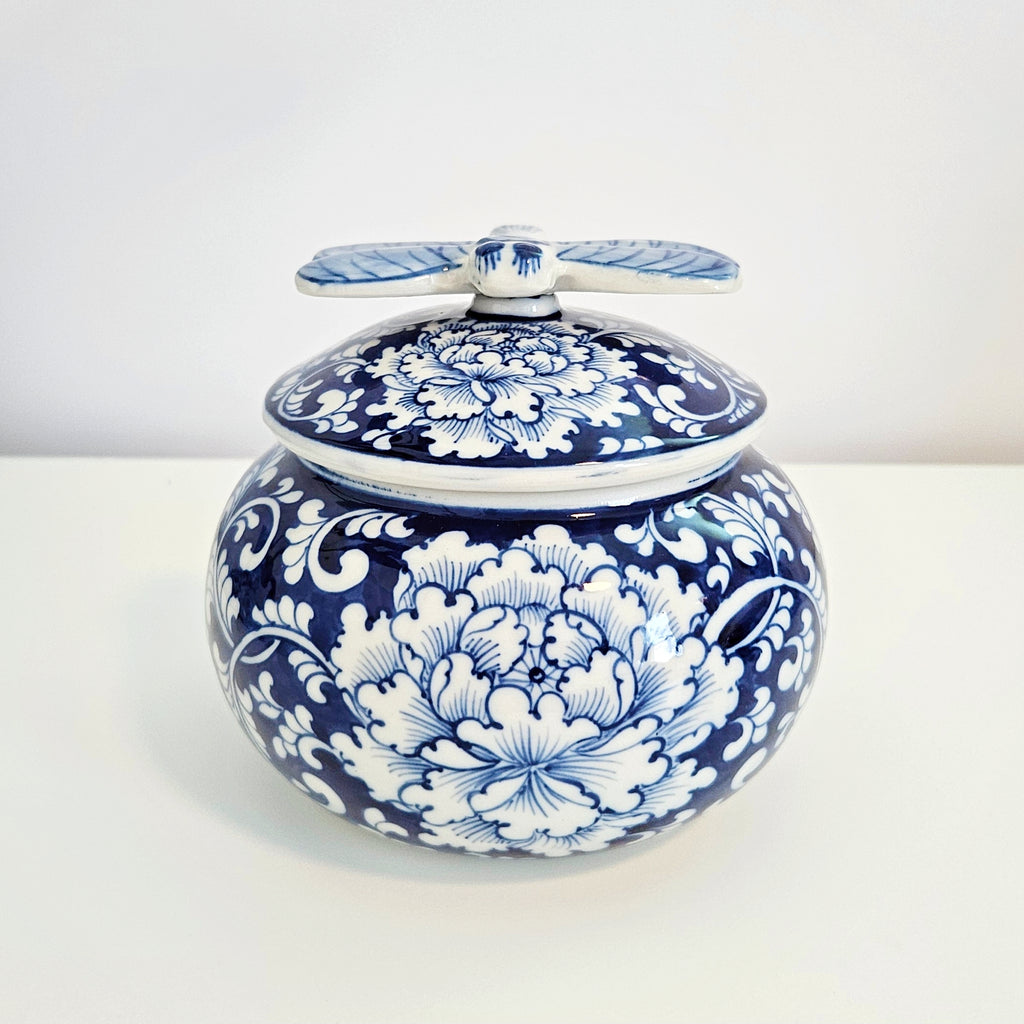 round chinoiserie blue and white porcelain jar with dragonfly lid feature peony flower, placing on a white table