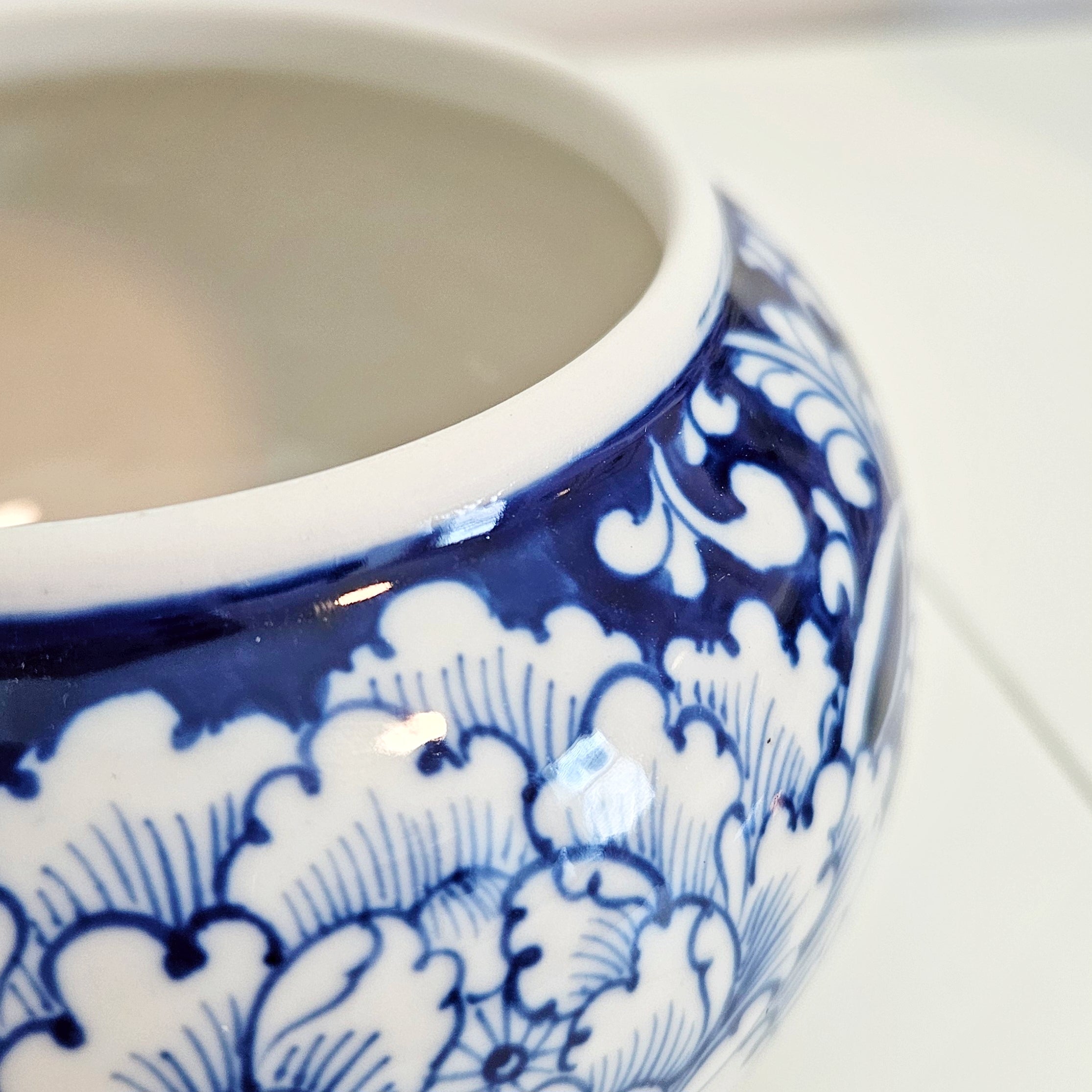 close up view of round chinoiserie blue and white canister with peony motif