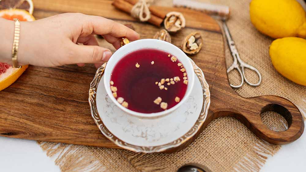 A woman drinking from a Vietnamese tea cup