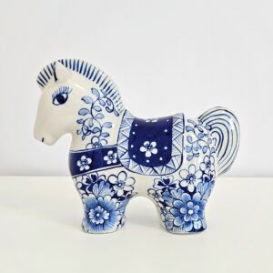 Hand-painted blue and white chinoiserie ceramic horse figurine with floral motif